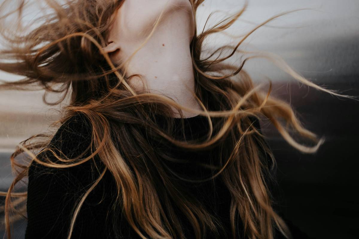 Woman applying lightweight hair weave as part of Thinning Solutions for fine hair